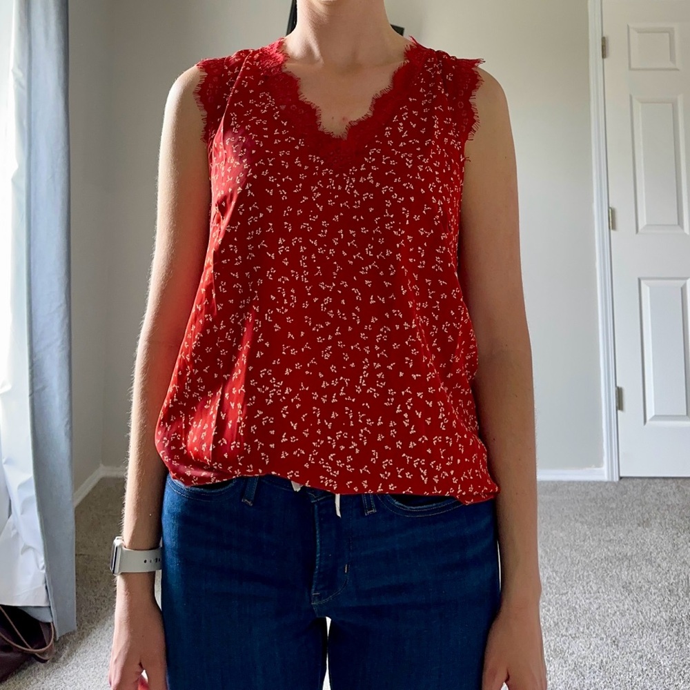 Red/rust colored cap sleeve shirt with lace detailing around neckline